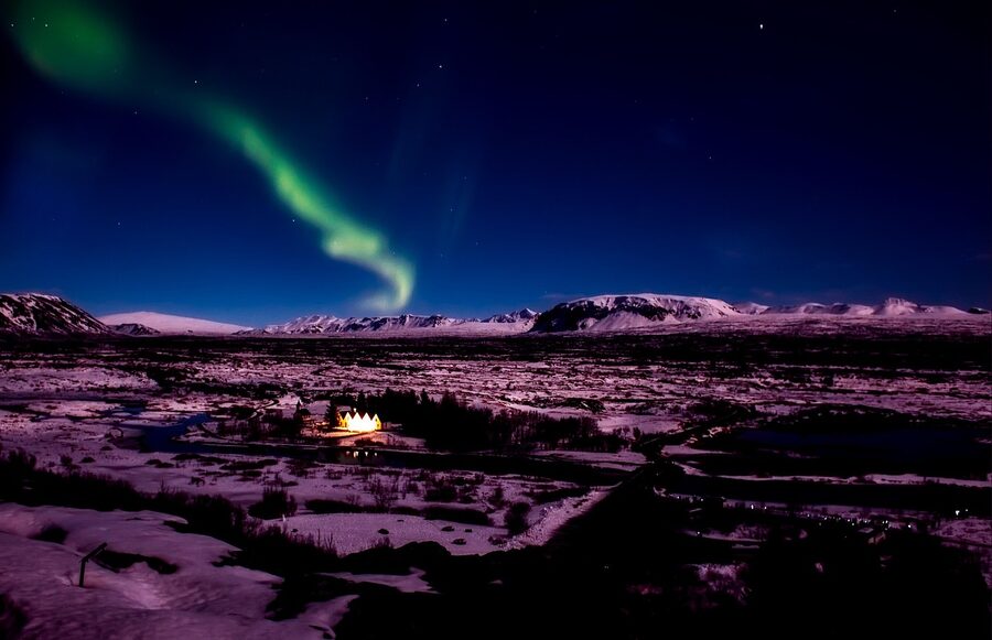 Aurora borealis over an Icelandic landscape with mountains