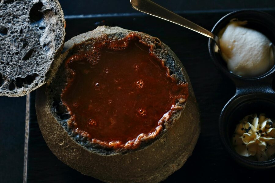 Bowl of Icelandic fish soup with bread on a wooden table