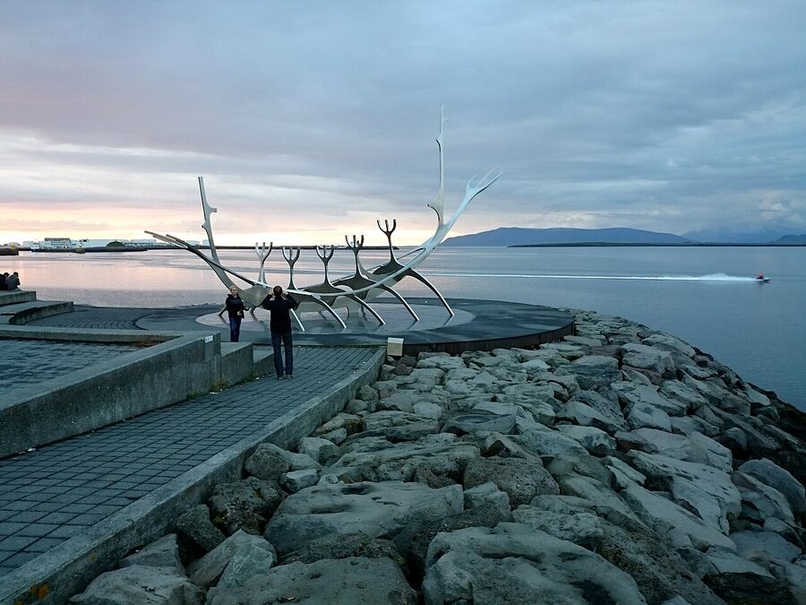 Sun Voyager sculpture on the Reykjavik waterfront with mountains behind