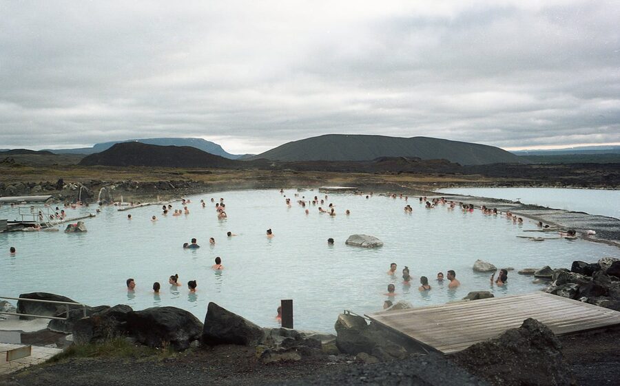 Bathers relaxing in a geothermal pool with steam rising