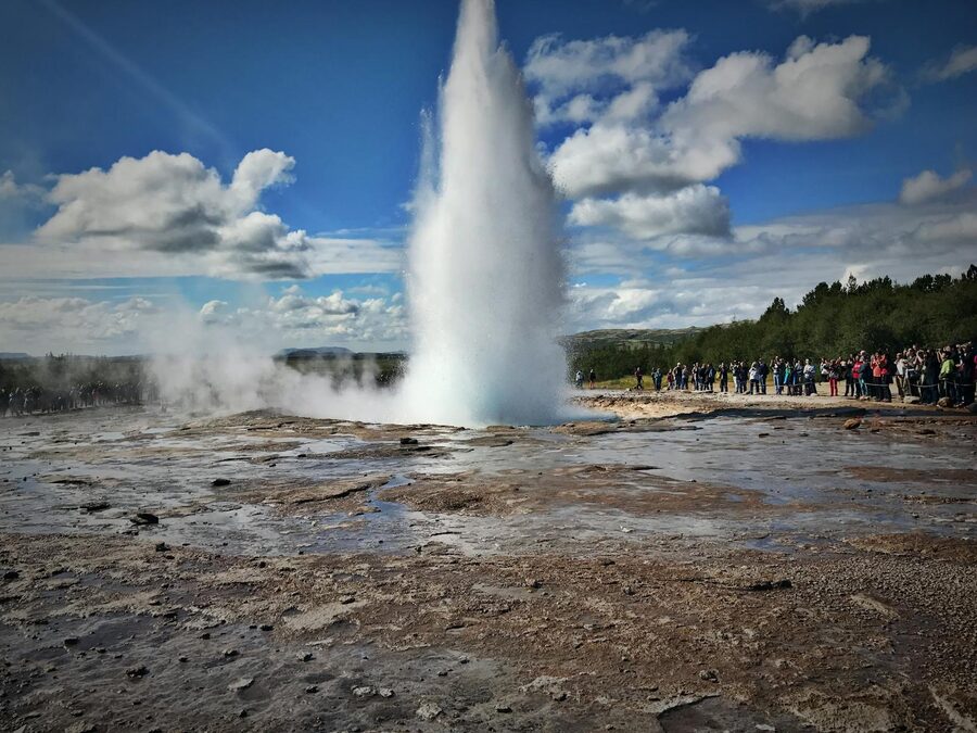 Group of visitors watching a geyser erupt at the Geysir field