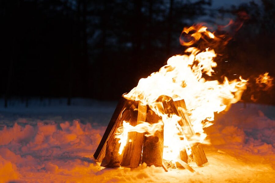 A bonfire burning in the snow at night during Þrettándinn