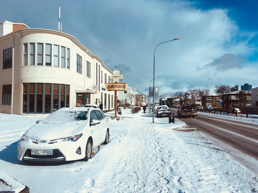 Snowy street in Reykjavik in winter with a parked car
