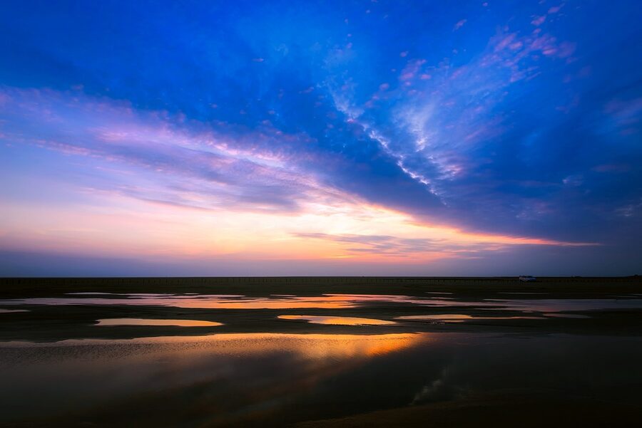 Sunset over an Icelandic marsh and lake with pink sky reflections