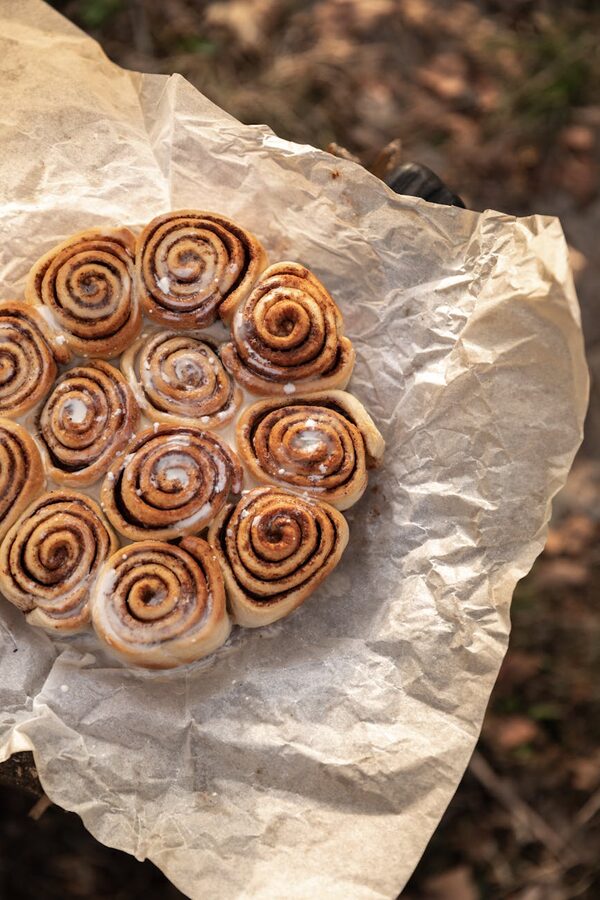 Warm cinnamon bun and hot chocolate on a wooden surface