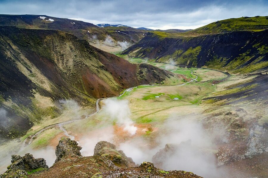 Steaming Reykjadalur Valley with hikers near the hot bathing river