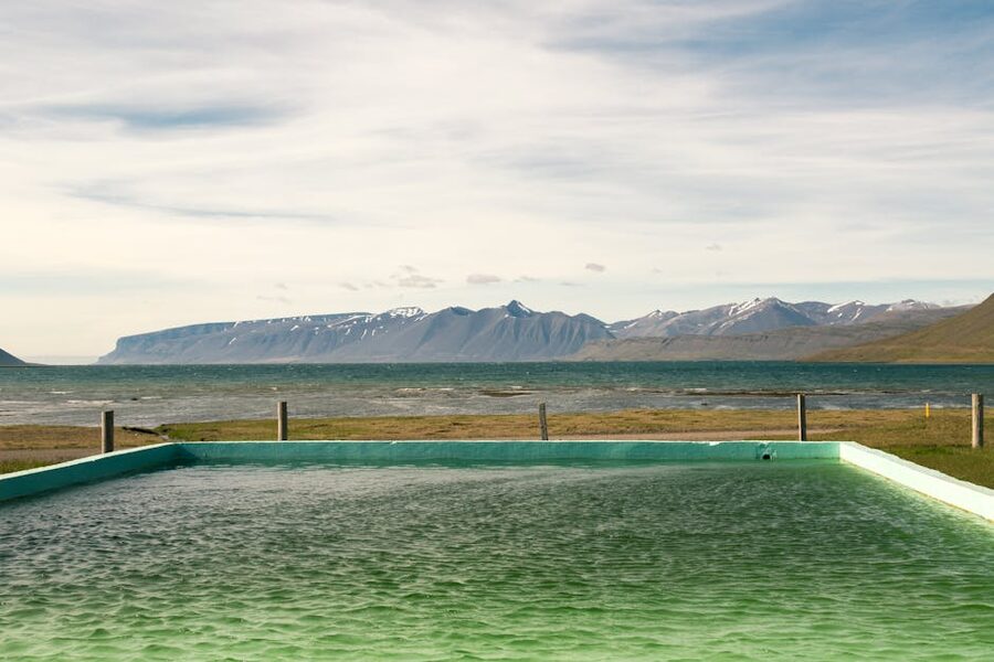 Outdoor geothermal pool in Iceland with mountain backdrop