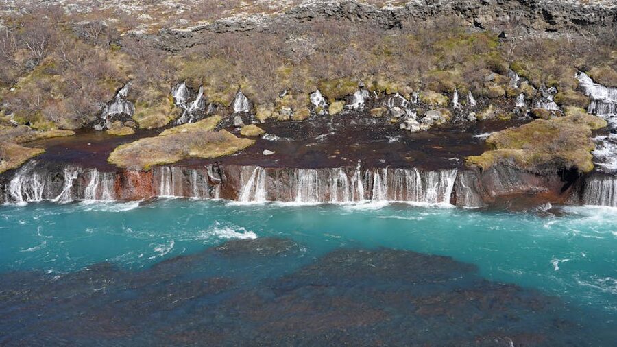 Hraunfossar waterfalls flowing into turquoise water in west Iceland