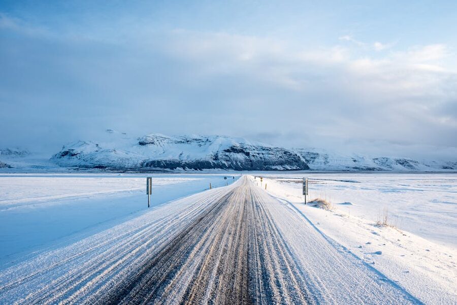 A snow-edged road leading toward mountains near Vik in winter
