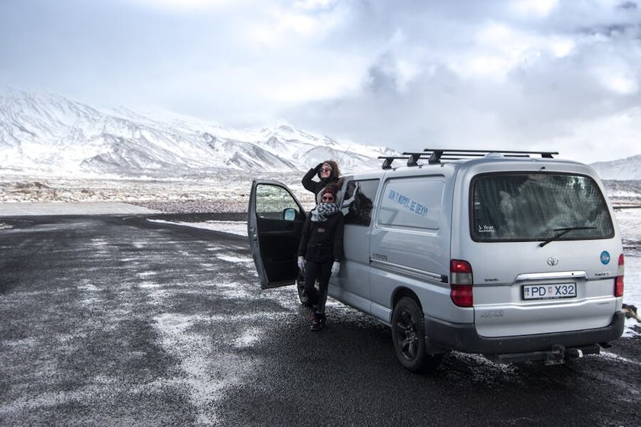 Travelers next to a campervan in Iceland snow