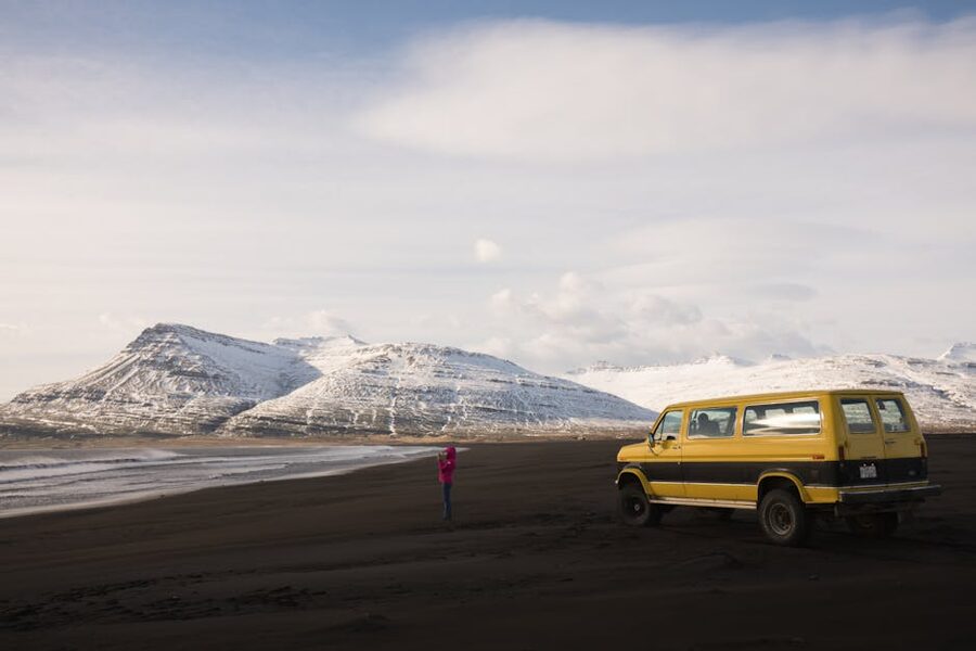 Yellow van on Reynisfjara black sand beach Iceland