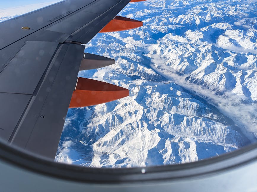 Aerial view of snowy mountains from the airplane window over Iceland
