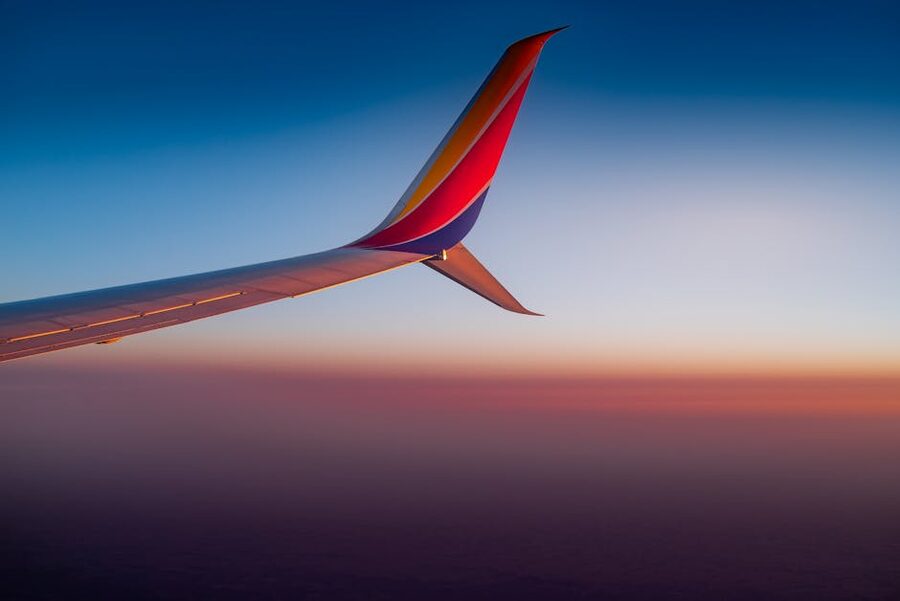 Airplane wing against a colourful sunset sky during a transatlantic flight