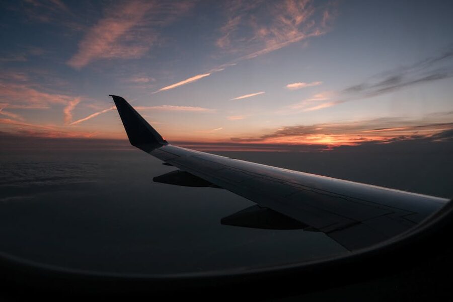 Airplane wing during sunset flight at high altitude