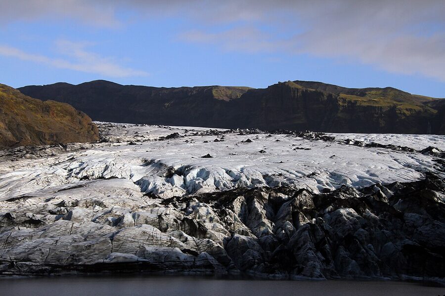 Guided group hiking single file on Sólheimajökull glacier in Iceland
