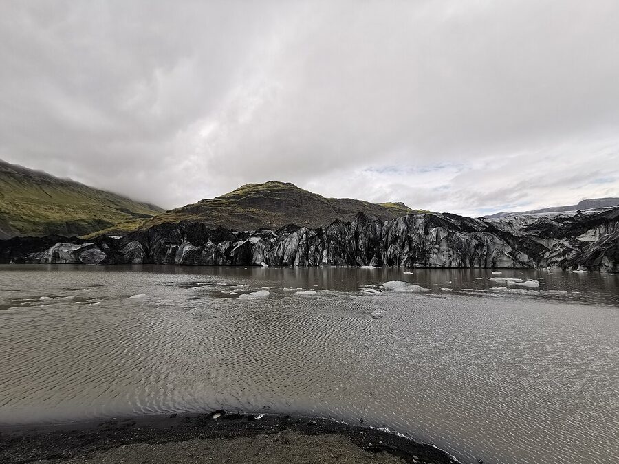 Solheimajokull glacier tongue with hikers approaching in southern Iceland