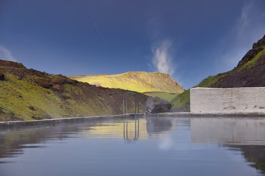 Hot spring pool in scenic Icelandic mountains with clear blue skies