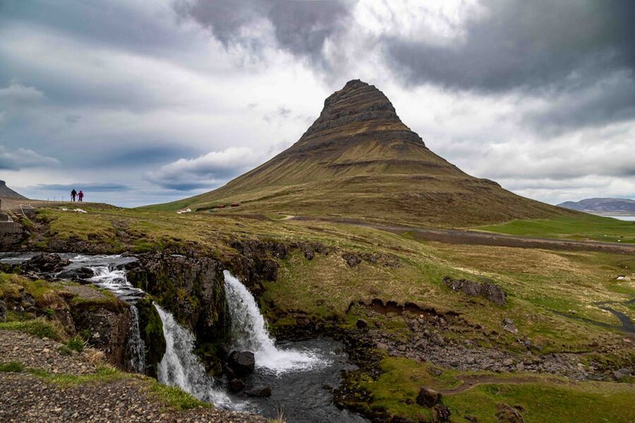 Kirkjufell mountain in Snæfellsnes peninsula with waterfall and dramatic clouds