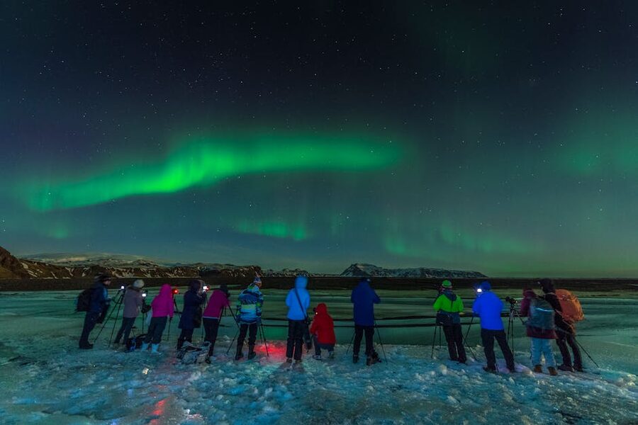 Group capturing the aurora borealis over Iceland with cameras