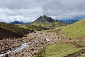 Hiker on the Laugavegur trail in southern Iceland with a layered weather system overhead