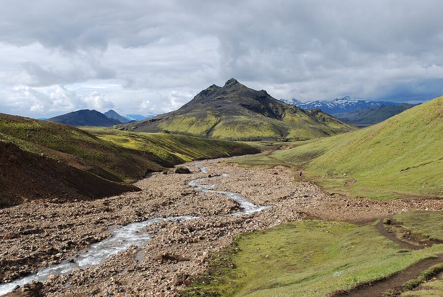 Hiker on the Laugavegur trail in southern Iceland with a layered weather system overhead