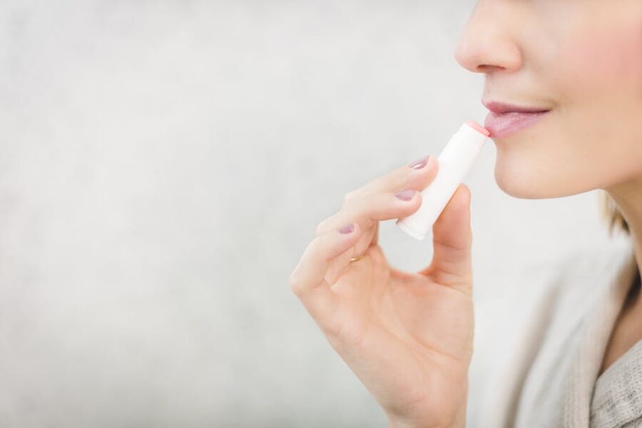 Woman applying lip balm in cold weather