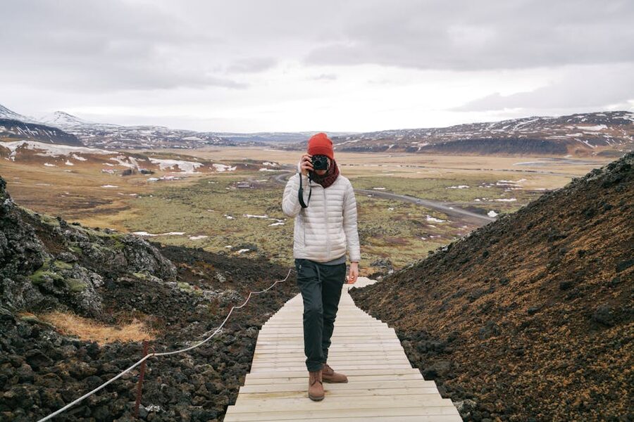 Photographer with camera on a wooden walkway in the Icelandic landscape