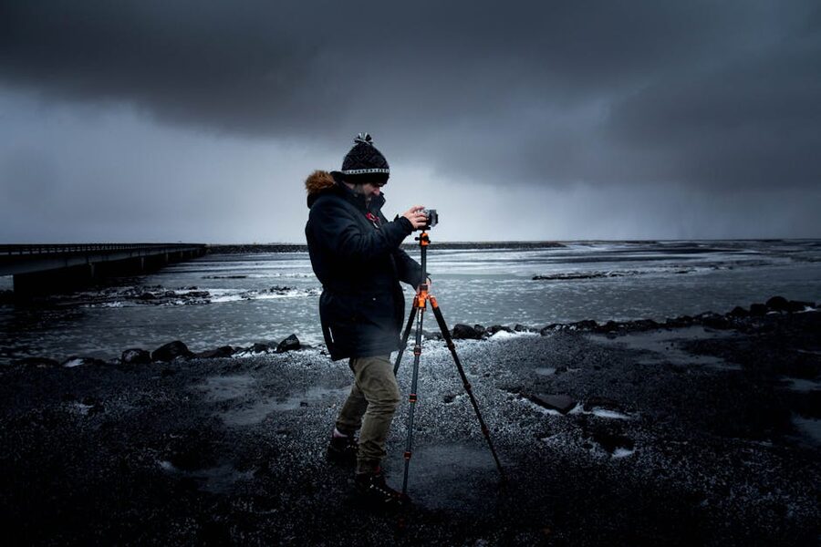 Photographer with tripod and camera in winter conditions