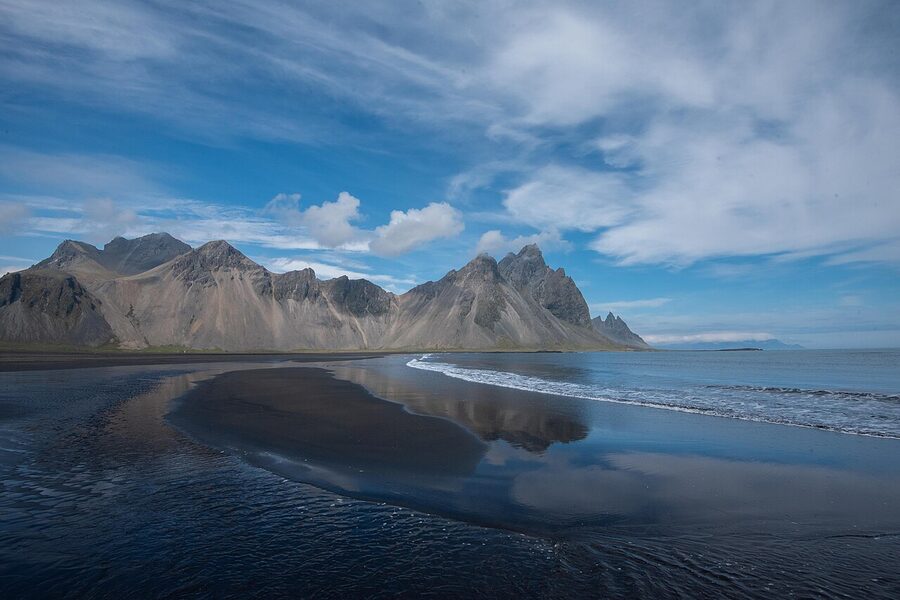 Vestrahorn mountain reflected in the Stokksnes black sand beach lagoon
