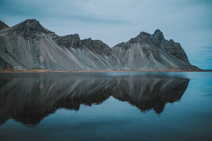 Vestrahorn mountain reflected in calm water at dusk in southeast Iceland