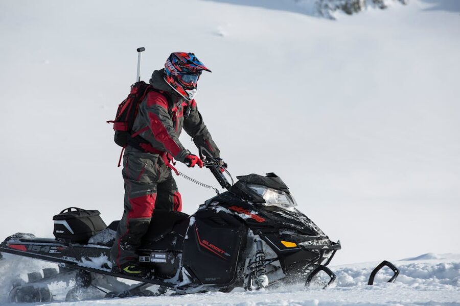 Snowmobile rider in protective helmet and snowsuit