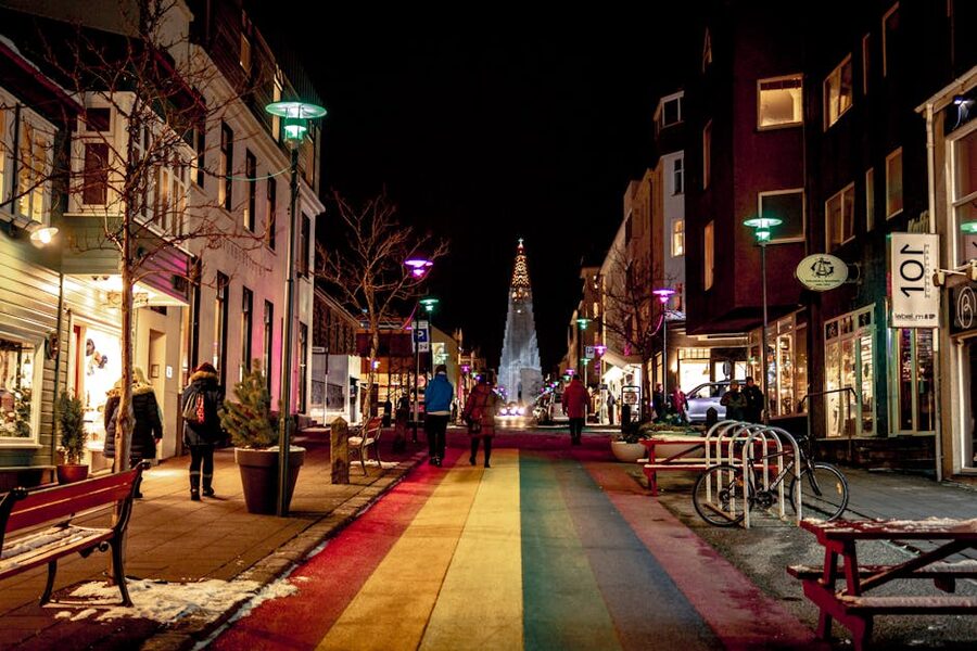 A snowy Reykjavik street lit by winter Christmas lights at night