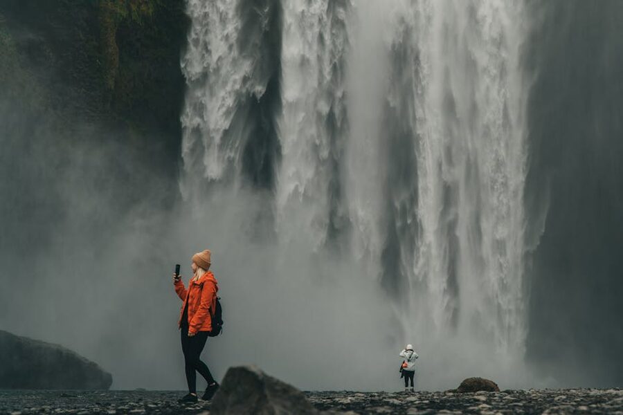Two travelers stopping at Skogafoss waterfall, south Iceland