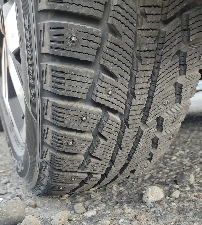 Close up of a studded winter tyre with metal studs