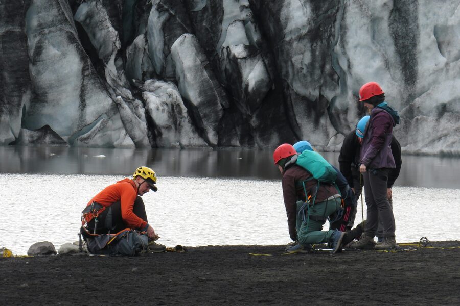 Group preparing crampons before a glacier hike near Vik in southern Iceland