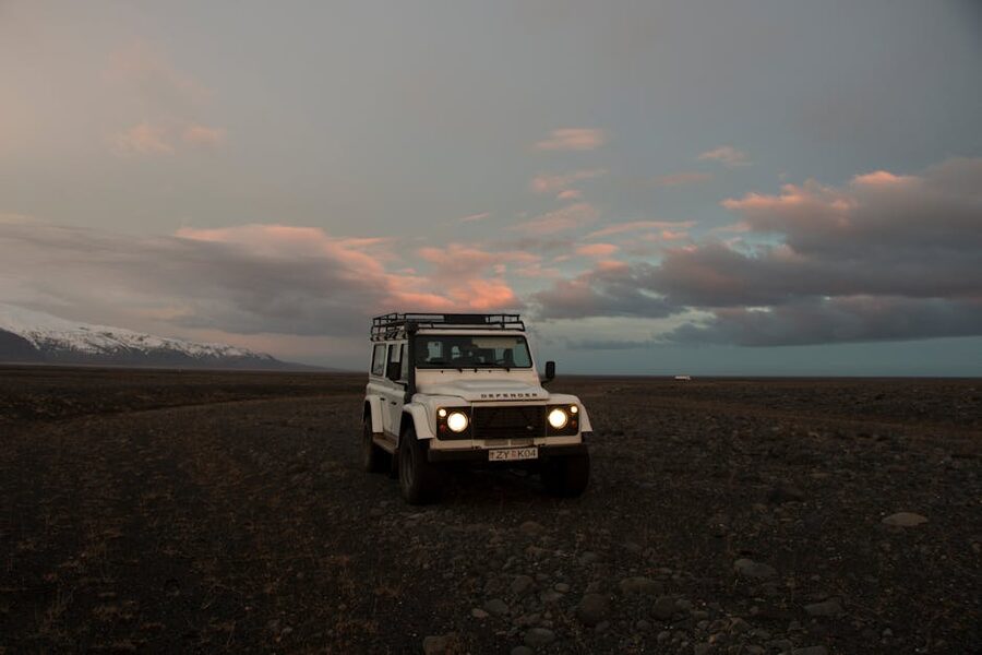 Land Rover Defender parked at dawn on rocky terrain in Iceland