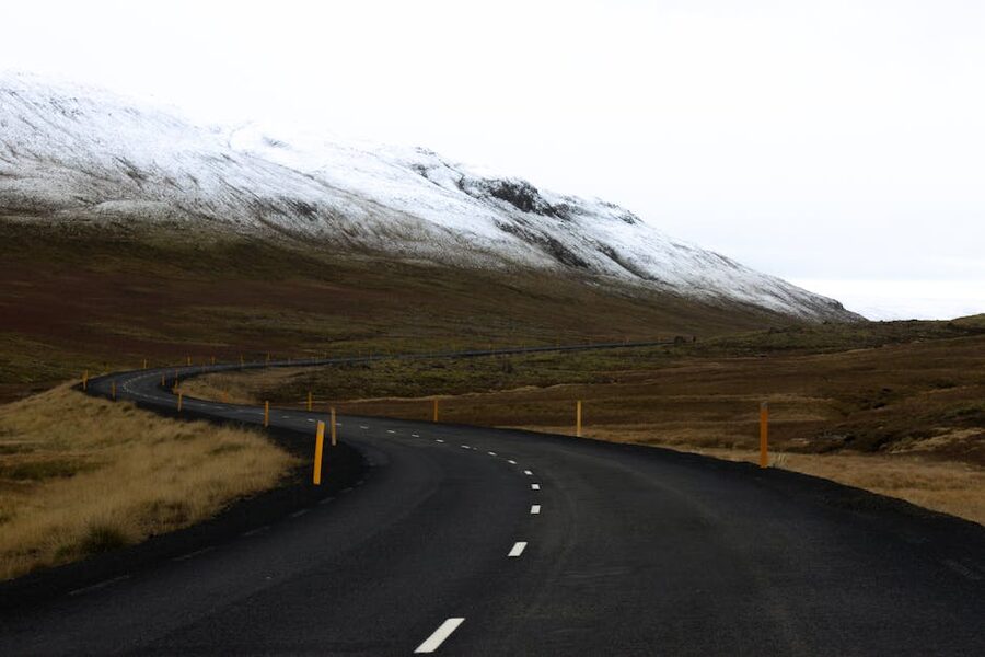Winding road through Iceland with snow-capped mountains and open landscape