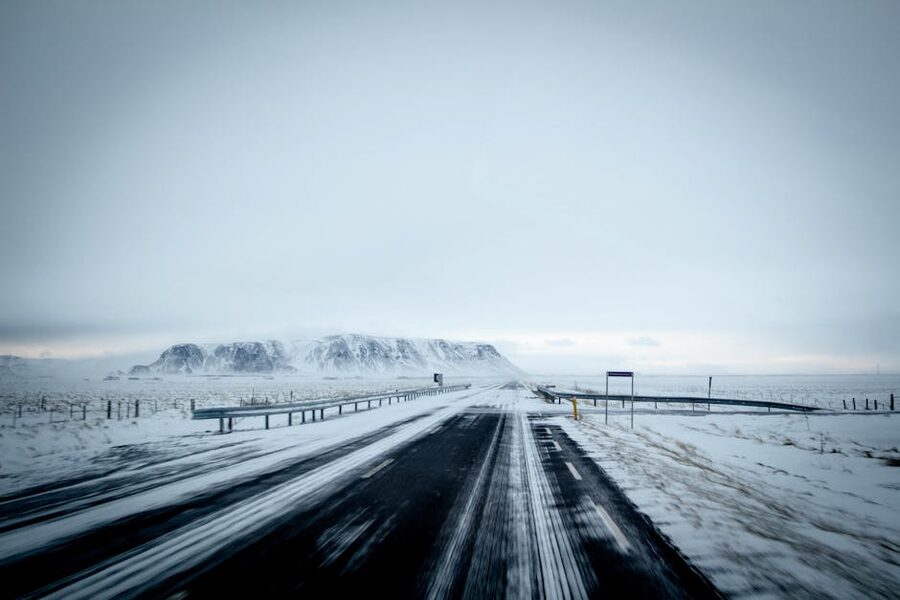 Serene winter scene with a snow-covered highway leading toward mountains in Iceland