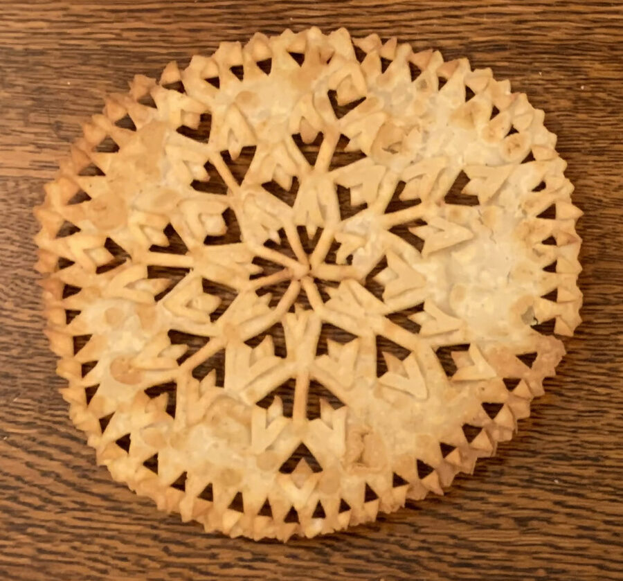 A single fried laufabrauð with intricate geometric cut-out patterns