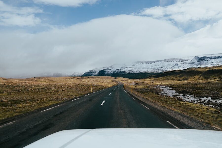 A road in Iceland leading toward snow-capped mountains in dramatic light