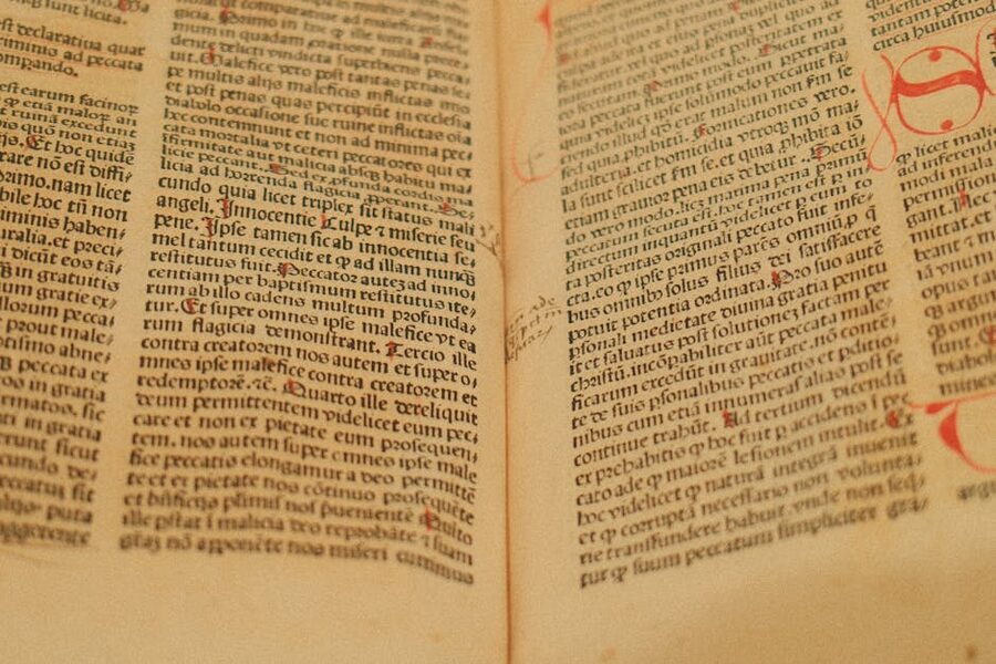 Close-up of an ancient manuscript with handwritten Latin text on yellowed parchment