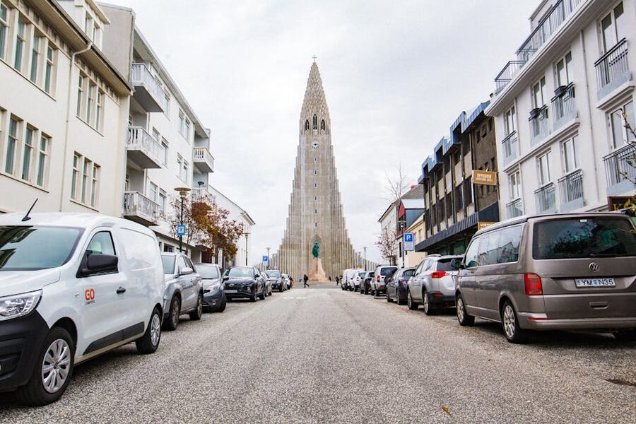 Reykjavik street view towards Hallgrímskirkja with parked cars and pastel buildings
