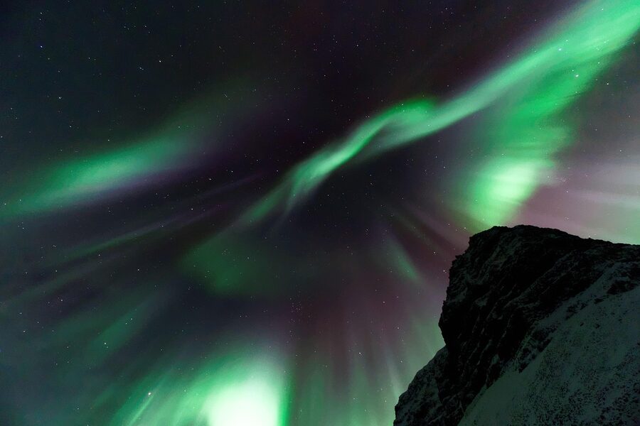 Aurora glowing above a dark Icelandic mountain