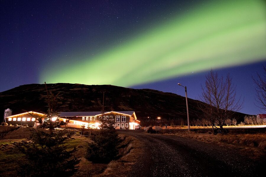Aurora glowing over a rural winter landscape in Iceland