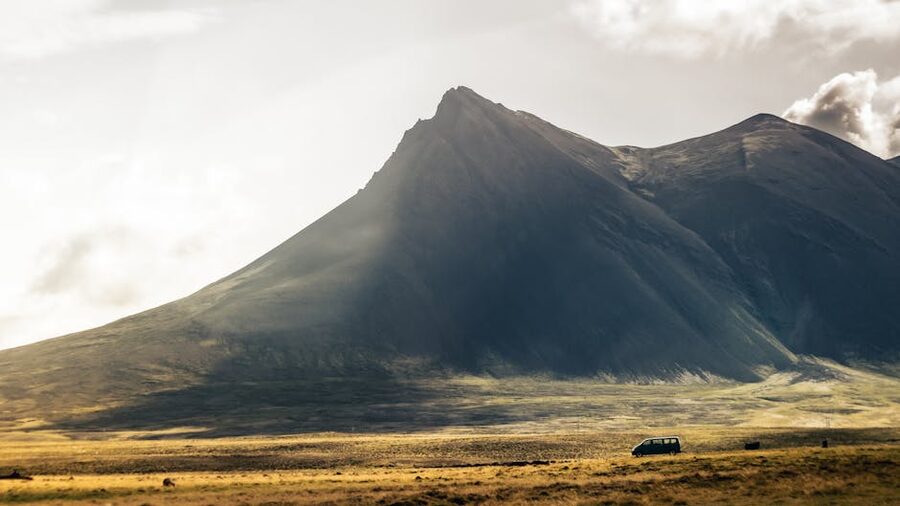 Camper van travelling on a road near a mountain in Iceland