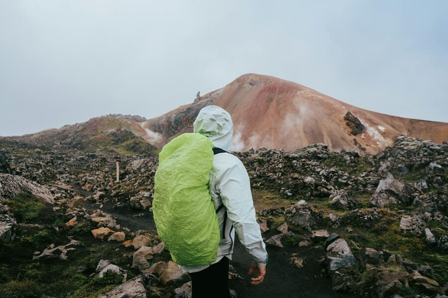 Backpacker on Landmannalaugar trail with rhyolite hills