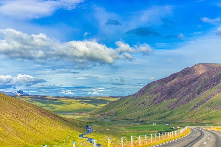 Winding road through a green valley in Iceland in summer