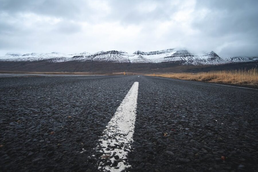 Road leading towards snow-capped mountains in Iceland