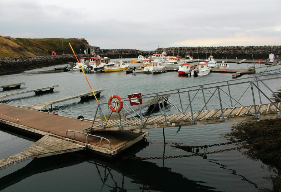 Iceland fishing harbour with boats and town behind