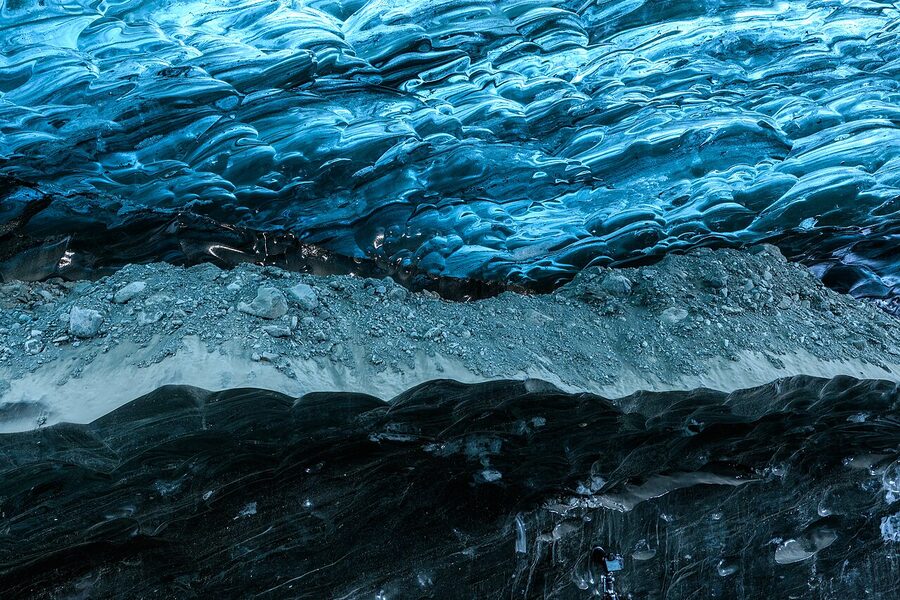 Person inside a blue ice cave at Vatnajokull glacier in Iceland